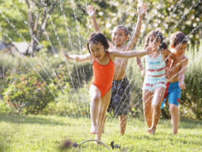 Children jumping through water fountain Children jumping through water fountain